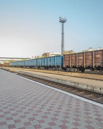 Грузовые вагоны на путях у пустой платформы